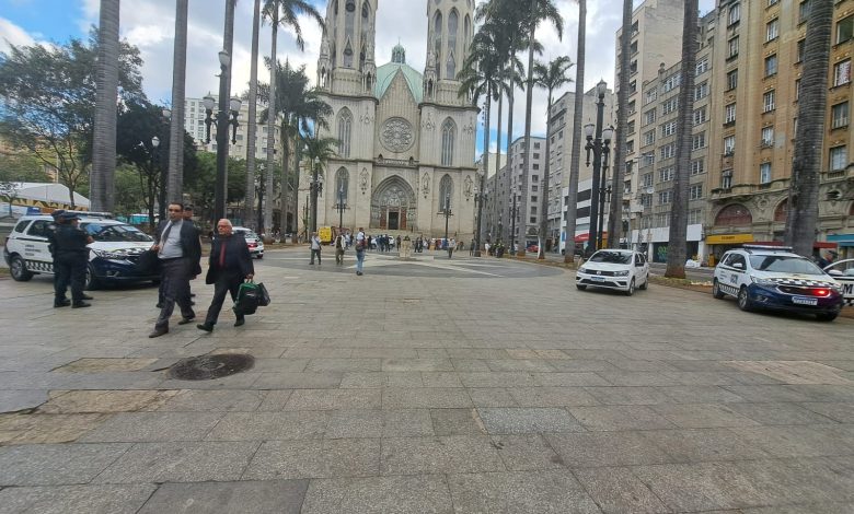 Moradores de rua na escadaria da Catedral da Sé se alimentando com